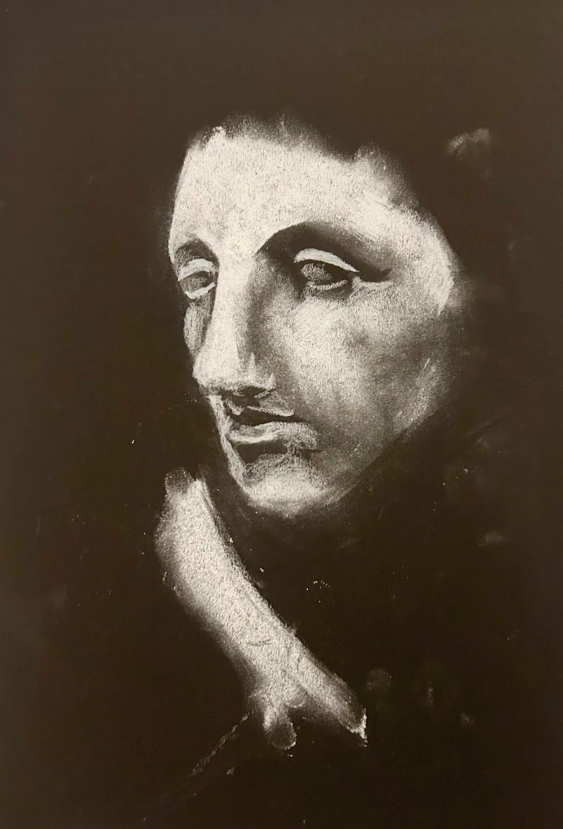 White-on-black chalk portrait of a face emerging from darkness.