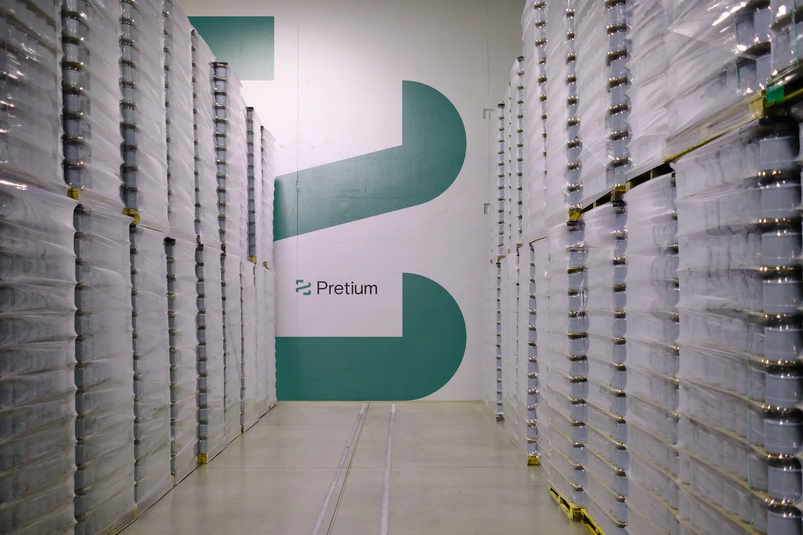 The new green Pretium brandmark painted large on a warehouse wall.